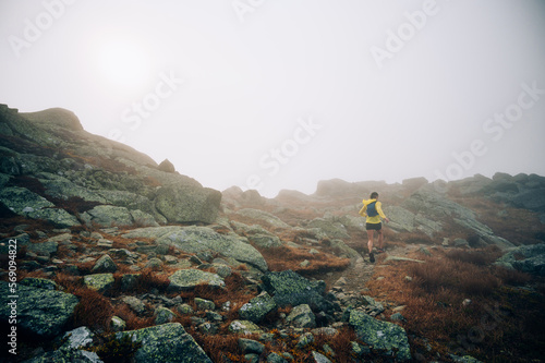 Woman trail running in fog on NH's Presidential Traverse photo