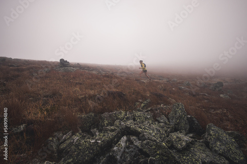 Woman trail running in fog on NH's Presidential Traverse photo