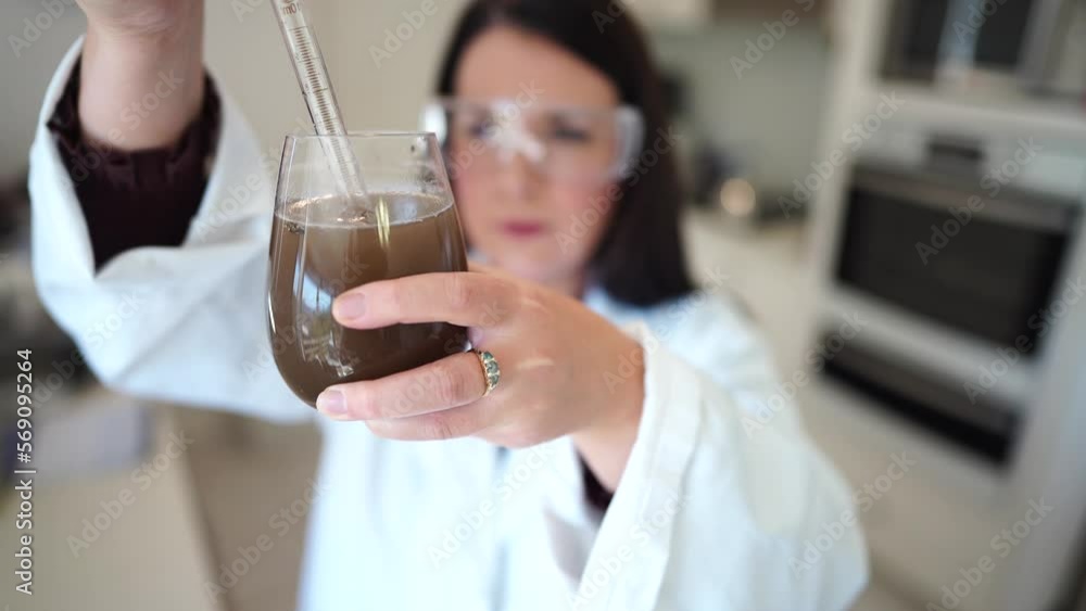 female soil scientist pipette soil solution in a laboratory. scientist working in agriculture. female soil scientist pipette soil solution in a laboratory. scientist working in agriculture.