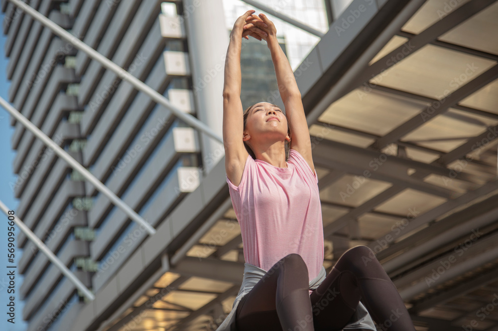Sport Fitness Woman stretching body exercise in modern city wear wellness sportswear outside. Young woman workout outdoor exercising on bright sunny outside. Healthy wellness lifestyle woman concept.