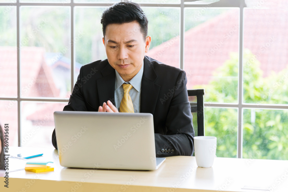 Asian Businessman using laptop at office desk. Man hands typing computer keyboard reading financial graph chart Planning analyzing marketing data. happy Asian business men people working office firm Asian Businessman using laptop at office desk. Man hands typing computer keyboard reading financial graph chart Planning analyzing marketing data. happy Asian business men people working office firm