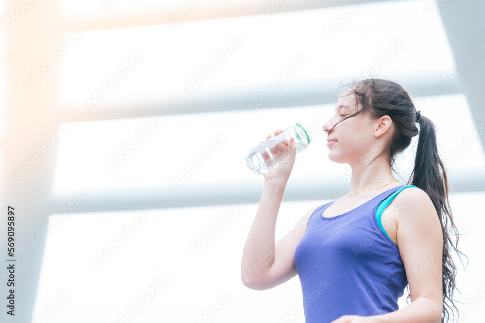 Women drinking water bottle running exercise in modern city wear wellness sportswear outside. Young woman workout outdoor exercising on bright sunny outside. Healthy wellness lifestyle woman concept Women drinking water bottle running exercise in modern city wear wellness sportswear outside. Young woman workout outdoor exercising on bright sunny outside. Healthy wellness lifestyle woman concept