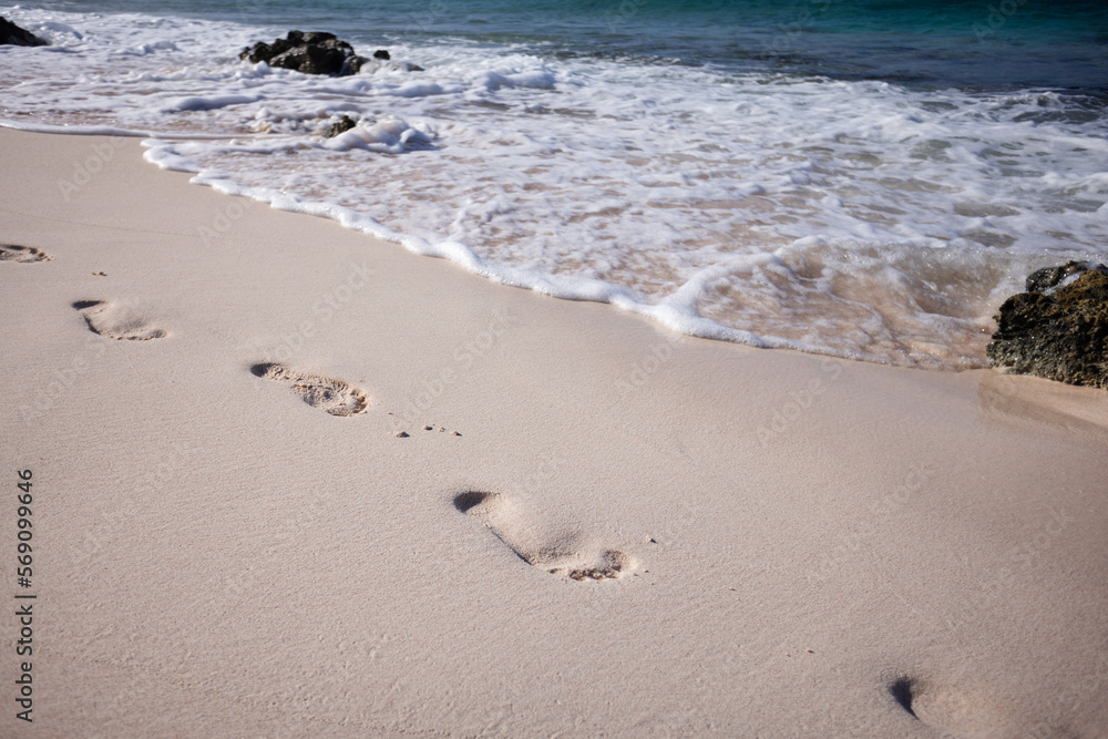 Texture background Footprints of human feet on the sand beach near turquoise sea water. Texture background Footprints of human feet on the sand beach near turquoise sea water.