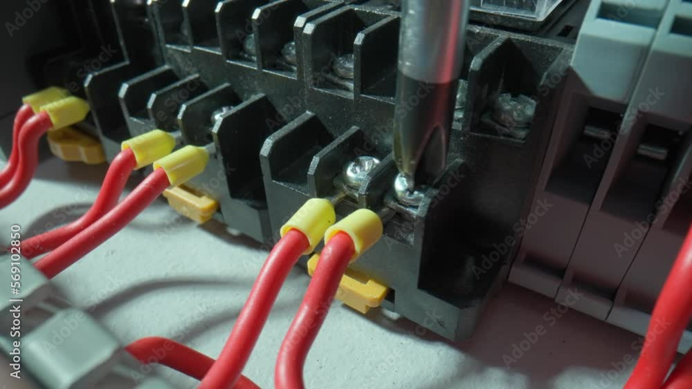 Gray plastic electrical panel with many red wires and yellow bushing ...