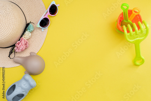 Top view of beach summer accessories for children. Fashion sunglasses, straw hat and beach toys. Vacation, holiday, summer, trip and travel concept. Flat lay. 