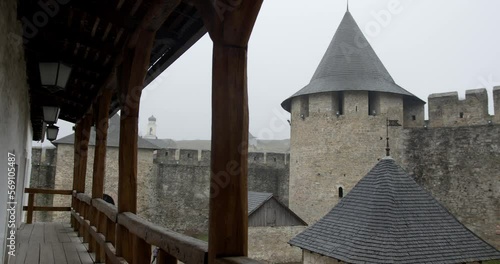 the courtyard of the Khotyn fortress with a loggia, a balcony with wooden columns against the background of the towers of the castle in Khotyn. rain photo