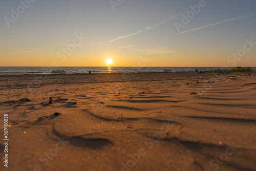 Close-up of the sea sandy beach. Panoramic beach landscape. Orange and golden sunset sky. Calm relaxing sunny summer mood. Holiday banner for recreation. Estonia  Narva-Jyesuu.