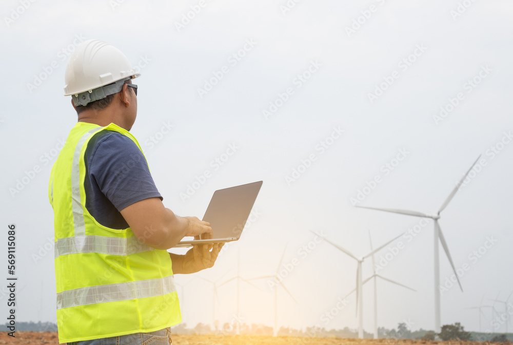 Engineer checking wind turbine operation on a laptop computer