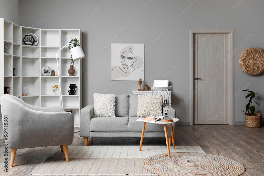 Cozy interior of living room with grey sofa armchair and painting