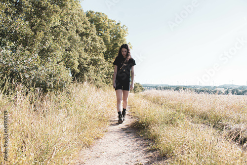 young woman hiking on a path in the middle of the forest © Cavan