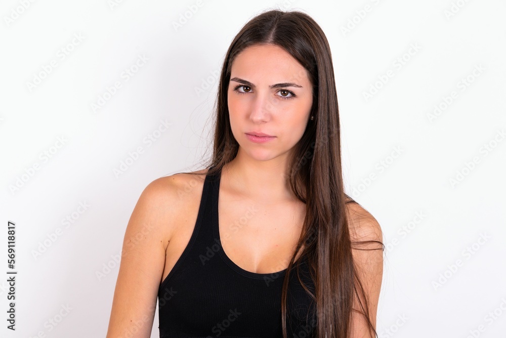 young woman wearing sportswear over white studio background frowning his eyebrows being displeased with something. young woman wearing sportswear over white studio background frowning his eyebrows being displeased with something.