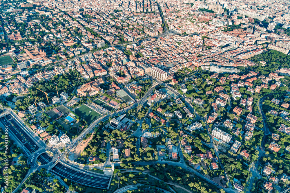 Aerial view of Tibidabo mountain neighborhood and Ronda de Dalt, with the typical buildings of Barcelona cityscape from helicopter. top view
