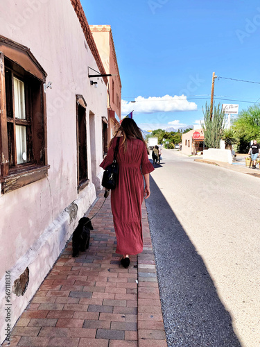 Latinx woman strolls through Old Mesilla with dog on summer vacation photo