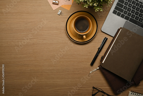 Top view of wooden working with laptop, books, glasses and coffee cup. Copy space for your text