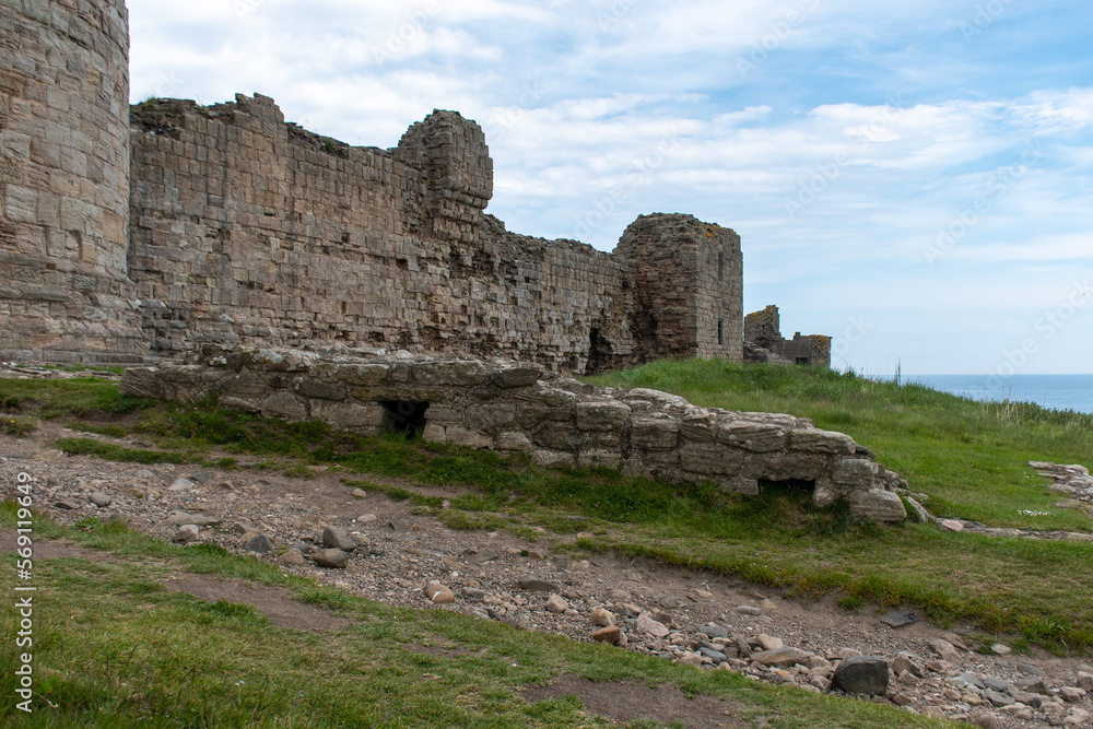 The ruined outer walls/defences of Dunstanburgh Castle, on the Northumberland coast, UK