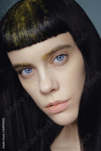 Fototapeta Naklejka Na Ścianę i Meble -  Model with gold glitter at brows and hair