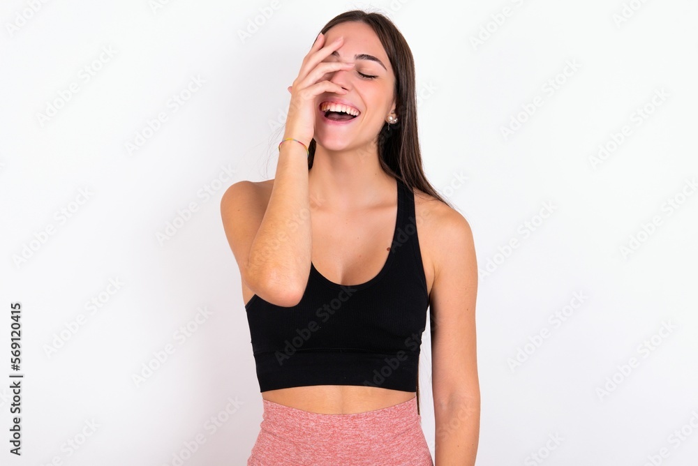 Charismatic carefree joyful young woman wearing sportswear over white studio background likes laugh out loud not hiding emotions giggling hear funny hilarious joke chuckling facepalm. Charismatic carefree joyful young woman wearing sportswear over white studio background likes laugh out loud not hiding emotions giggling hear funny hilarious joke chuckling facepalm.