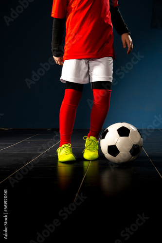 A child football player in yellow sneakers standing with a ball © Vesna