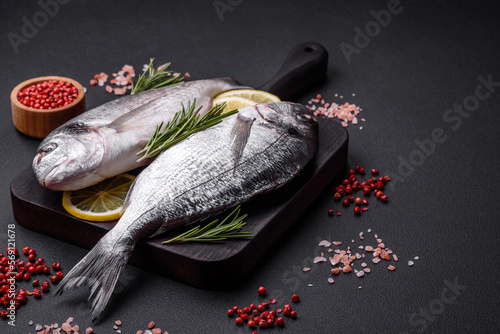 Tableau sur toile Fresh raw dorado fish with spices, herbs, salt and lemon