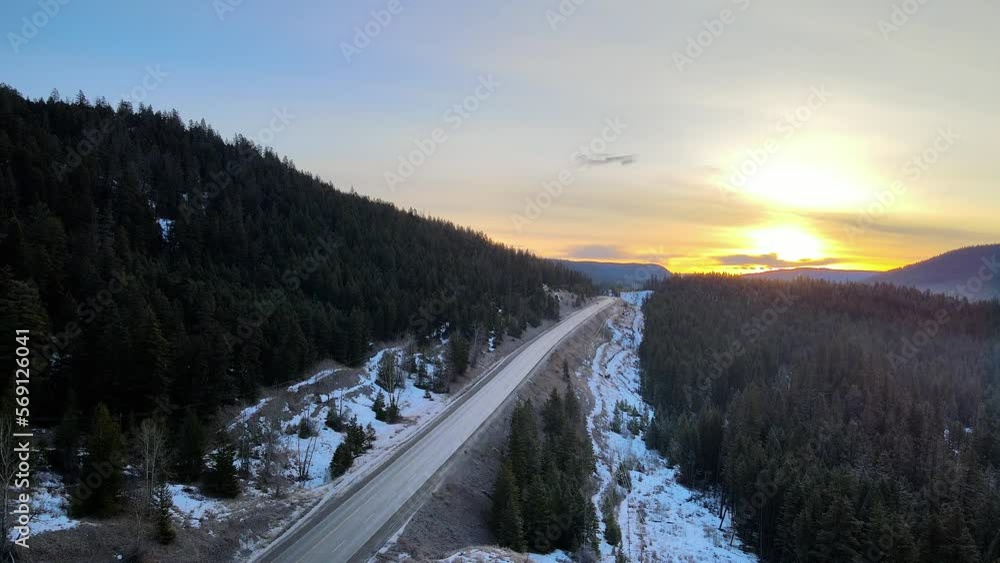 An Aerial shot of Cars driving on Cariboo Highway 97 During a Winter Sunrise in British Columbia, Canada An Aerial shot of Cars driving on Cariboo Highway 97 During a Winter Sunrise in British Columbia, Canada