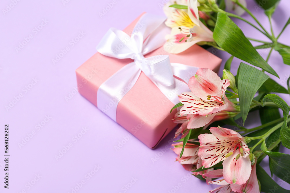 Beautiful alstroemeria flowers and gift for Women's Day celebration on lilac background Beautiful alstroemeria flowers and gift for Women's Day celebration on lilac background