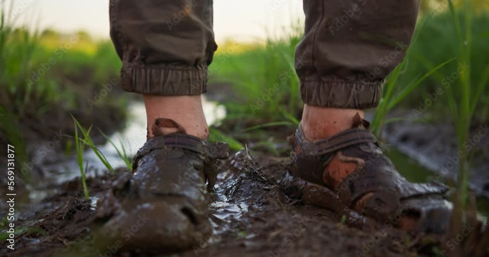 A man stands in dirty shoes on wet ground in nature. Shoes close-up. Traveler stuck in the mud A man stands in dirty shoes on wet ground in nature. Shoes close-up. Traveler stuck in the mud