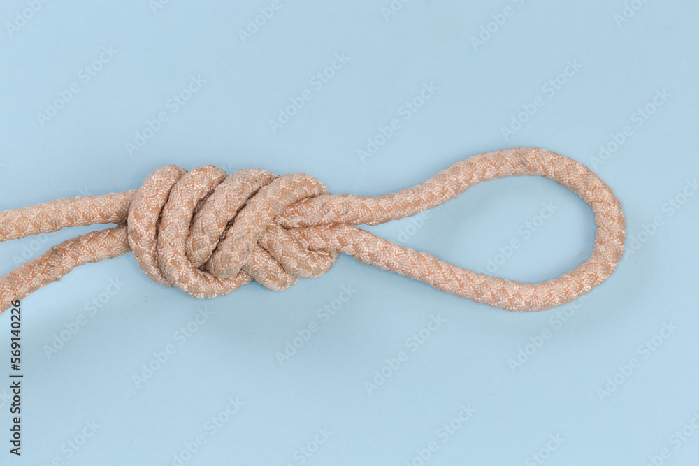 Obraz premium Rope knot Figure-nine loop on blue background close-up
