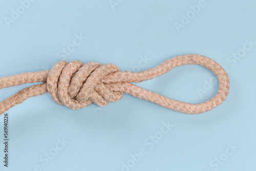 Rope knot Figure-nine loop on blue background close-up