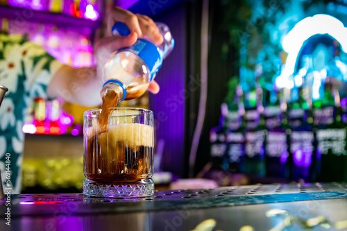 Photography bartender making Cuba Libre cocktail in bar