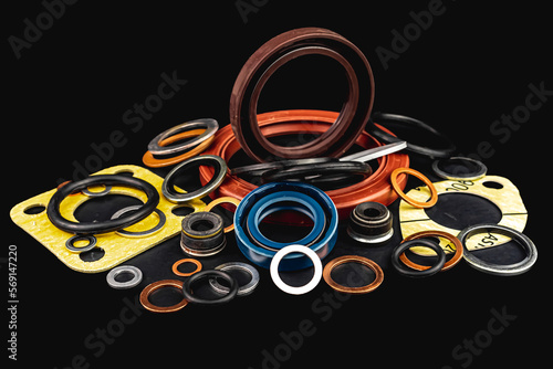 Gaskets and seals, Oil seal, Copper washers, seal for valve stem oil, Black hydraulic and pneumatic o-ring, isolated on black background photo