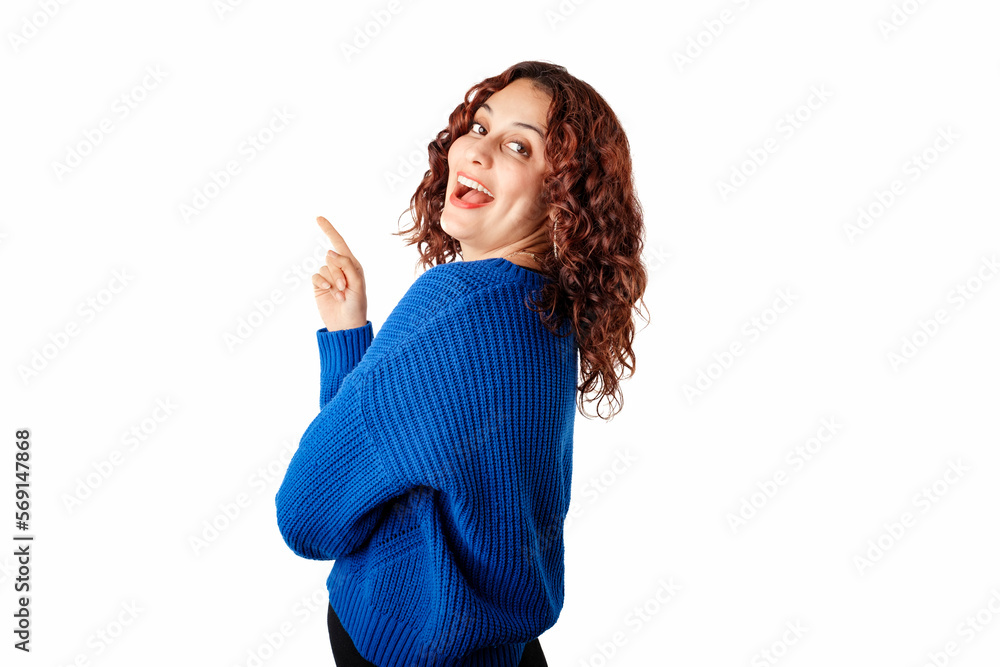 Side view of woman wearing blue knitted sweater standing isolated over white background looking back at the camera over shoulder with a smile. Confident and laughing.