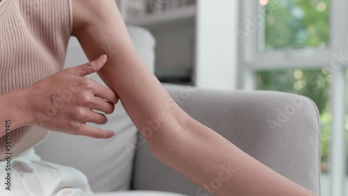 Wallpaper Mural Footage close up of Unhappy Asian woman suffering from pain in arm while sitting on the couch in the living room. Health care and medical concepts. Torontodigital.ca