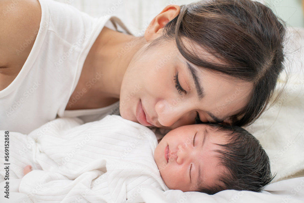 happy loving family. mother playing with her baby hugging in the bedroom , portrait of asian mother playing with newborn baby, health care family love together. asian girl lifestyle.. happy loving family. mother playing with her baby hugging in the bedroom , portrait of asian mother playing with newborn baby, health care family love together. asian girl lifestyle..