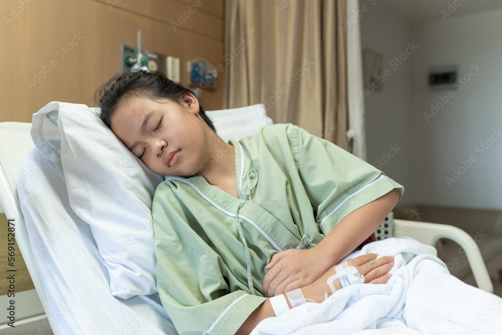 Asian young beautiful female lying on the bad having stomach ache and IV saline drip to back of hand lying on bed in hospital, medical and health concepts. Asian young beautiful female lying on the bad having stomach ache and IV saline drip to back of hand lying on bed in hospital, medical and health concepts.