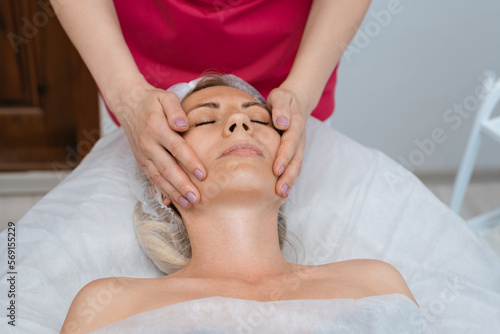 Face massage. Young woman getting spa massage treatment at beauty spa salon. Skin and body care. Facial beauty treatment