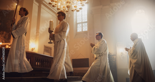 Liturgy in Grand Church: Majestic Procession Of Ministers, Priests Walking with Processional Cross to Altar. Congregation Stands In Reverence, Christians Rejoice In Mass Ceremony