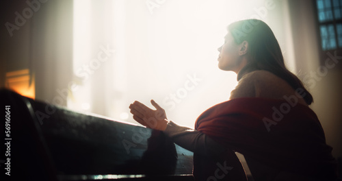 Stampa su tela Young Christian Woman Sits Piously in Majestic Church, with Folded Hands She Seeks Guidance From Faith and Spirituality while Praying