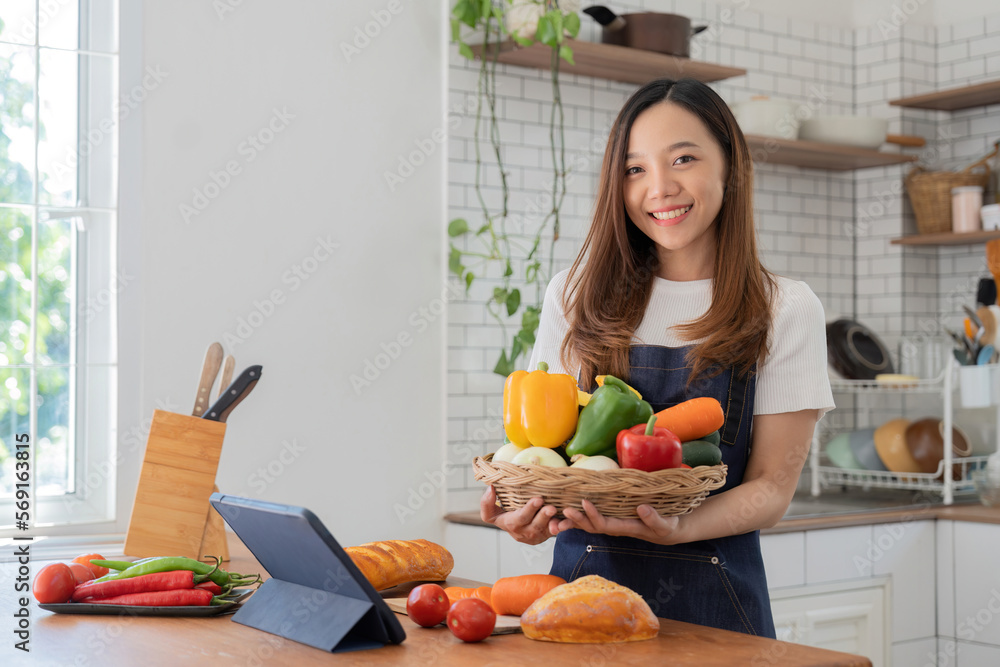 woman in the kitchen preparing materials ready to cook looking at recipes on tablet woman in the kitchen preparing materials ready to cook looking at recipes on tablet