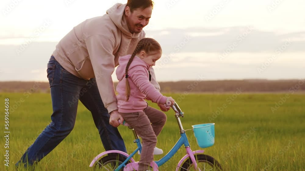happy dad teaches little child ride two wheel bike. concept happy