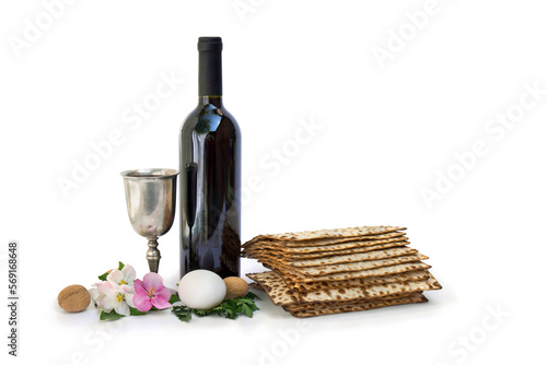 Matzo, wine, silver bowl, pink flowers apple tree, white egg and walnuts for passover celebration on white background with space for text