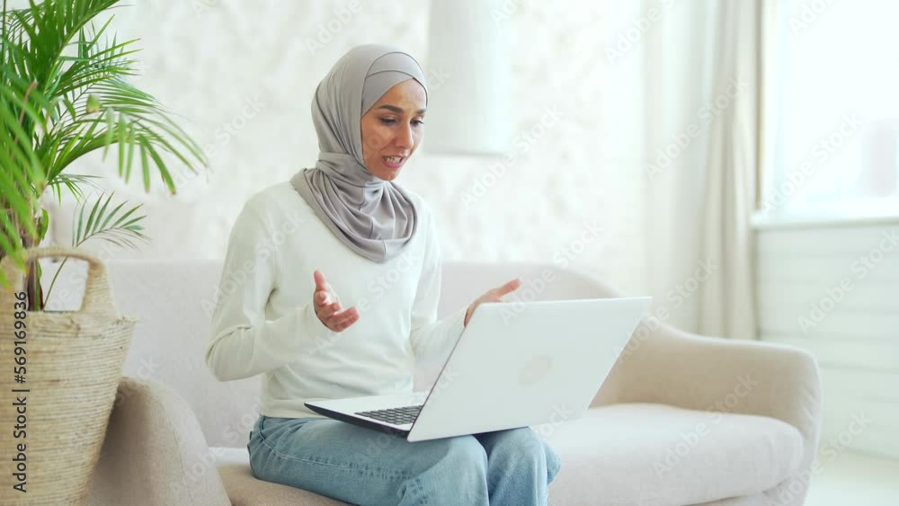 Young Muslim woman in hijab businesswoman having working conversation online female freelancer or teacher talking by video call on laptop computer remote communication meeting conference at home Young Muslim woman in hijab businesswoman having working conversation online female freelancer or teacher talking by video call on laptop computer remote communication meeting conference at home