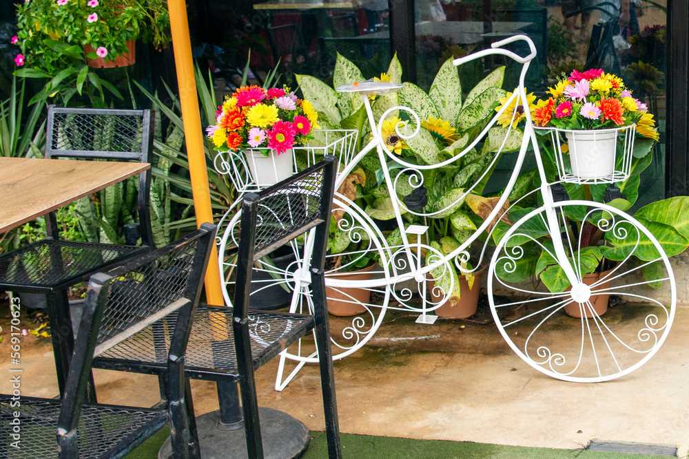 White bicycle with flower pot decoration in cafe