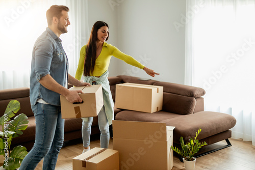 Smiling couple unpaking boxes in new home photo