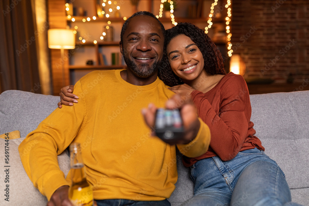 Family portrait of loving black couple watching TV at home Stock Photo ...