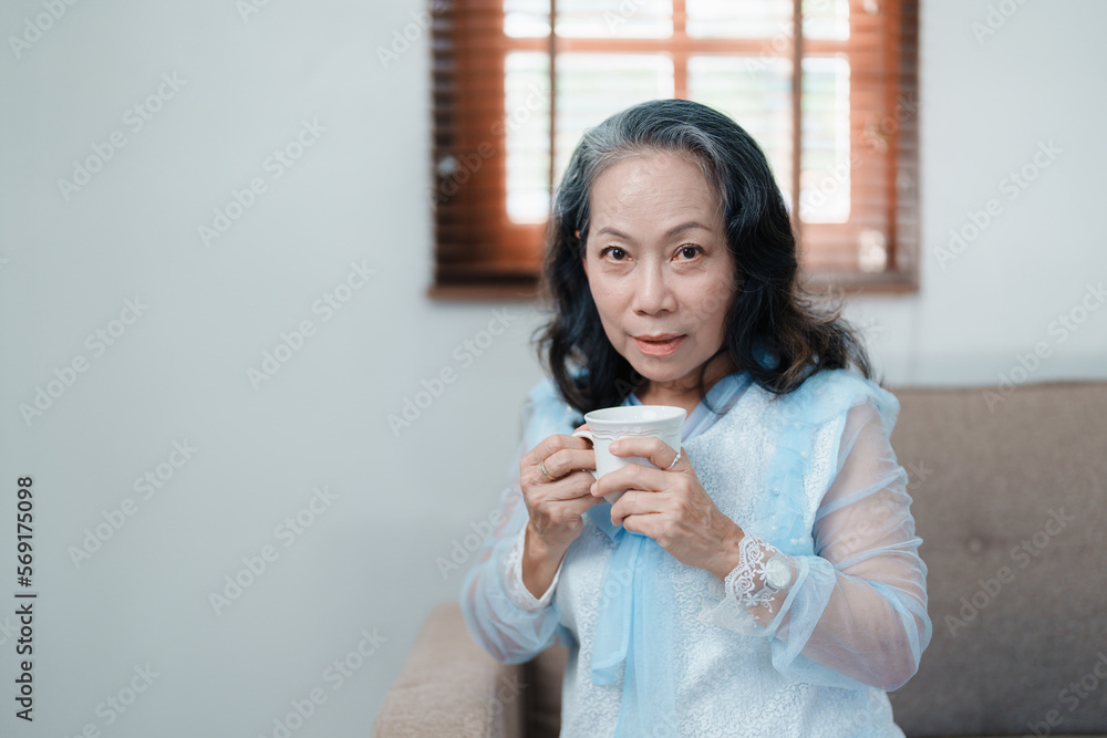 Portrait of an elderly Asian woman drinking tea for health.