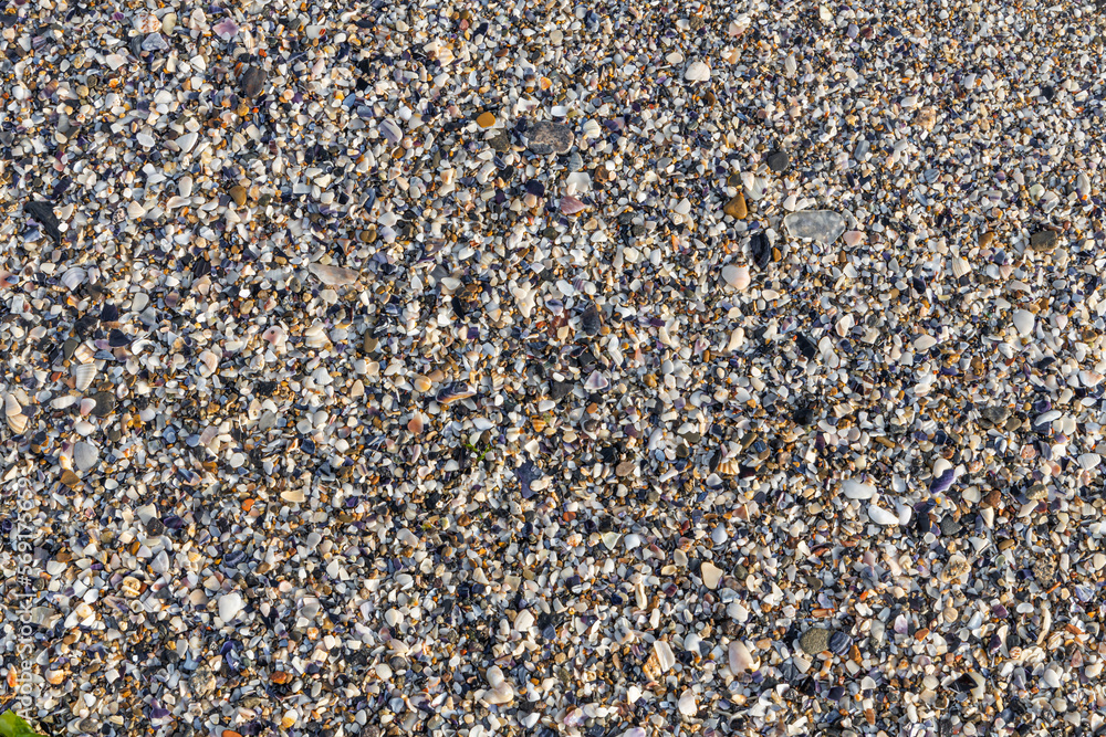 Beautiful horizontal texture of yellow sand with waves pebbles and shells is in the photo Beautiful horizontal texture of yellow sand with waves pebbles and shells is in the photo