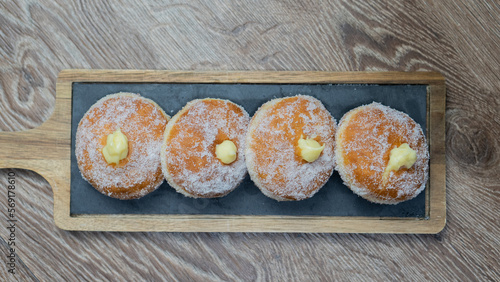 Homemade fried donuts filled with custard and seasoned with a veil of sugar 