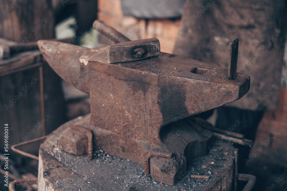 Process metal with hammer on anvil in forge. Strike iron outdoors in workshop. Metalworking, blacksmithing. Process metal with hammer on anvil in forge. Strike iron outdoors in workshop. Metalworking, blacksmithing.