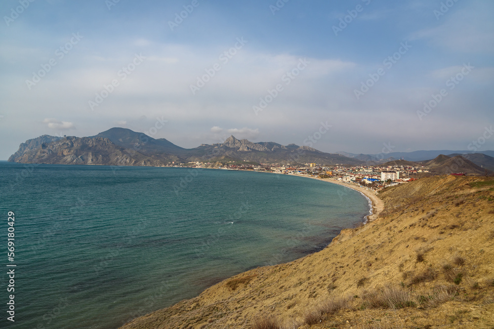 View of seaside resort city Koktebel , mountain Kara Dag from hill in spring. Crimea View of seaside resort city Koktebel , mountain Kara Dag from hill in spring. Crimea