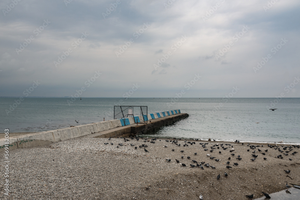 Stone pier on the emnankment of Feodosiain cloudy weather. Crimea Stone pier on the emnankment of Feodosiain cloudy weather. Crimea